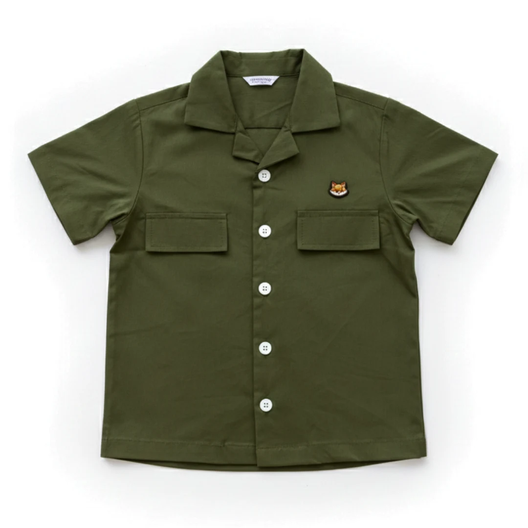 A premium olive green Cuban collar shirt for boys, The Safari Shirt by Orange, laid flat to show the cotton fabric.
